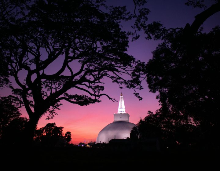 Stunning view of the Ruwanweli Maha Seya stupa against a vibrant twilight sky in Anuradhapura, Sri Lanka.